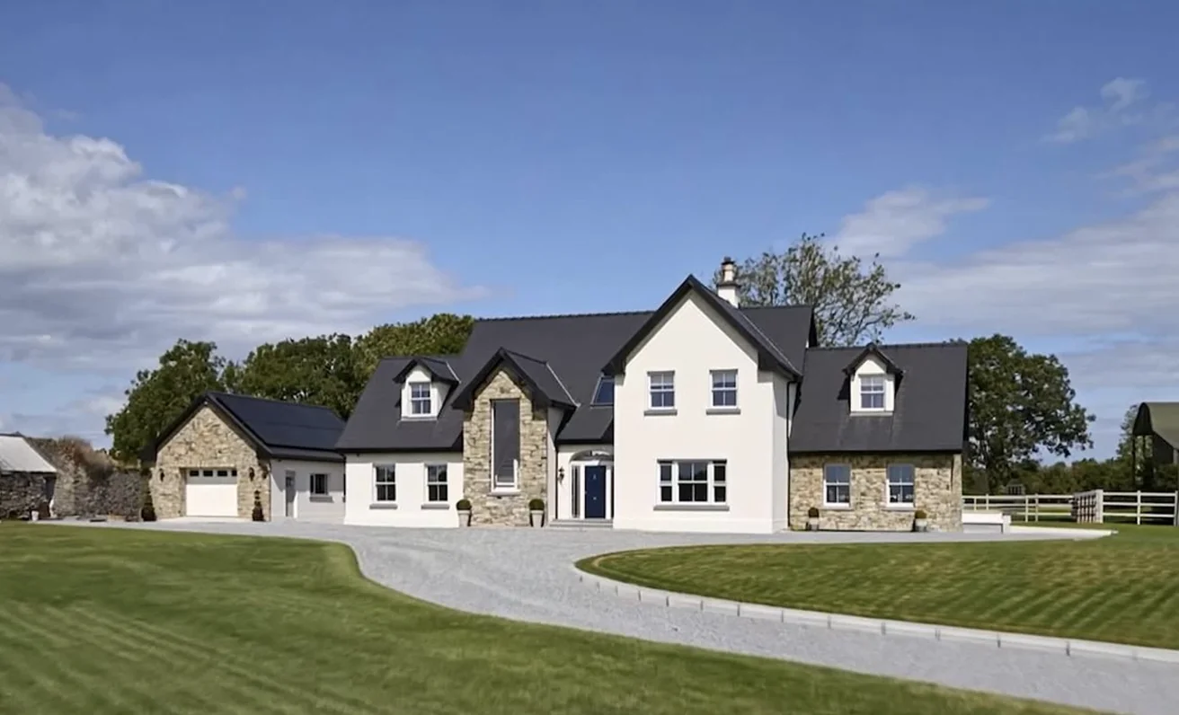 Irish country house featuring grey windows and a navy door set against a stone facade - Senator Windows