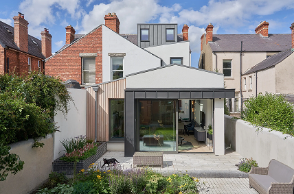 Contemporary home extension with anthracite grey aluminium sliding doors creating a seamless connection between the indoor living space and landscaped garden - Senator Windows