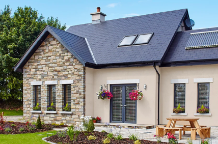 Senator refurb door featuring dark grey frames set in a stone-clad cottage with hanging floral baskets - Senator Windows