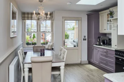 Senator replacement uPVC door in a light cream finish leading from a classic kitchen to a patio - Senator Windows