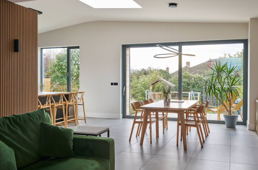 Modern home extension with large aluminium sliding doors opening onto a garden