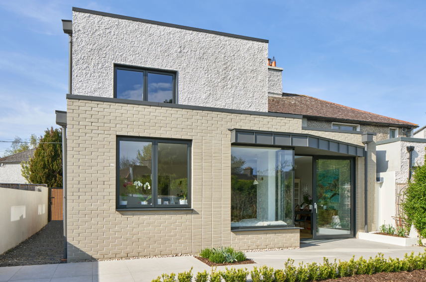 Dark grey aluminium windows and sliding patio doors on a modern home extension - Senator Windows